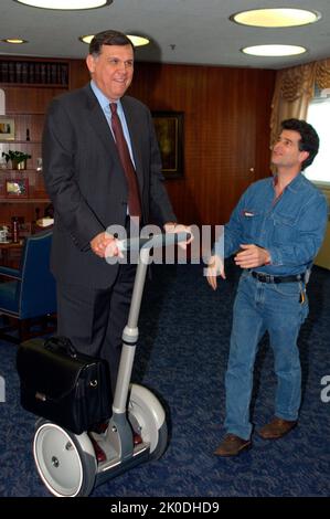 Secretary Mel Martinez, Staff Sampling Personal Transportation Device. Secretary Mel Martinez, Staff Sampling Personal Transportation Device Subject, Secretary Mel Martinez, other senior staff testing the Segway Human Transporter during visit to HUD Headquarters by the Segway's inventor, Dean Kamen. Stock Photo