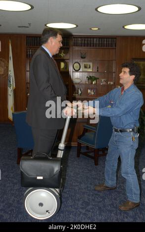 Secretary Mel Martinez, Staff Sampling Personal Transportation Device. Secretary Mel Martinez, Staff Sampling Personal Transportation Device Subject, Secretary Mel Martinez, other senior staff testing the Segway Human Transporter during visit to HUD Headquarters by the Segway's inventor, Dean Kamen. Stock Photo