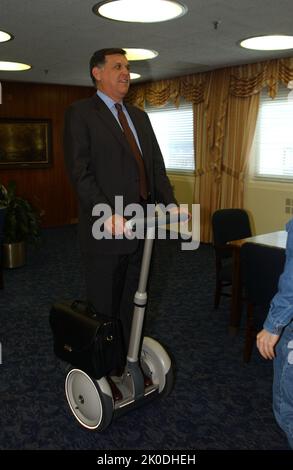 Secretary Mel Martinez, Staff Sampling Personal Transportation Device. Secretary Mel Martinez, Staff Sampling Personal Transportation Device Subject, Secretary Mel Martinez, other senior staff testing the Segway Human Transporter during visit to HUD Headquarters by the Segway's inventor, Dean Kamen. Stock Photo