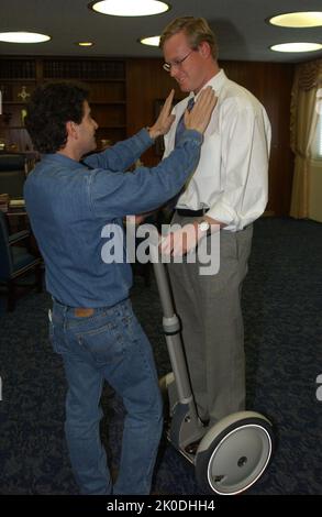 Secretary Mel Martinez, Staff Sampling Personal Transportation Device. Secretary Mel Martinez, Staff Sampling Personal Transportation Device Subject, Secretary Mel Martinez, other senior staff testing the Segway Human Transporter during visit to HUD Headquarters by the Segway's inventor, Dean Kamen. Stock Photo