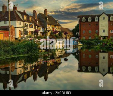 Evening golden hour by the River Avon in the Cotswold town of Tewkesbury. Looking towards Abbey Mill and the cottages on Mill Bank and St Mary's Road. Stock Photo