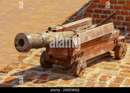 Old cannon over stone wall. Old castle. Ancient cannon on wheels. Stock Photo