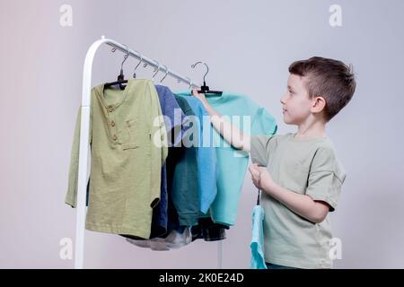 Boy Preschooler Standing Hangers Racks Clothes Chooses Clothes Today Stock  Photo by ©volody100@ukr.net 575619300