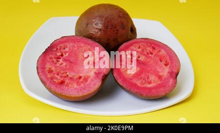 Ripe red guava fruit served on a small plate Stock Photo