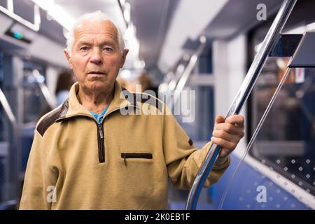 Elderly man in subway train Stock Photo