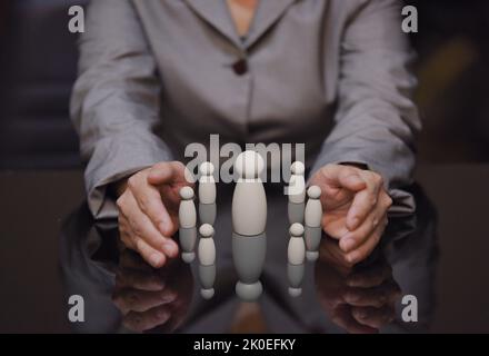 business woman holding wooden human team, working connection and team work coordination in organization and relationship protection Stock Photo