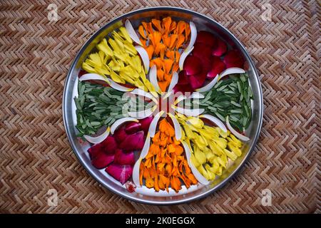 Aarti thali decoration. Hand made diy craft with flowers, flower petals of rosr, marigold, amla leaves. Thaali or plate decorated with flowers to make Stock Photo