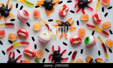 Close-up bright jelly candies,spiders,eyes,jaws,worms and bats,on white background,top view,flat lay,copy space.Decor concept for Halloween party,holi Stock Photo
