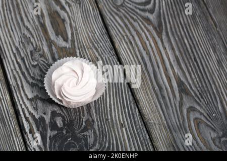 Zephyr in a paper bowl. On pine boards. Close-up. Stock Photo