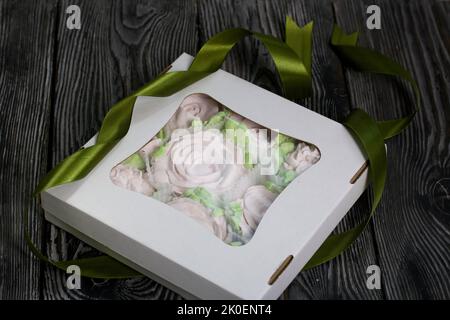 Zephyr flowers. Zephyr in a cardboard box. Tape for tying the box. On pine boards. Stock Photo