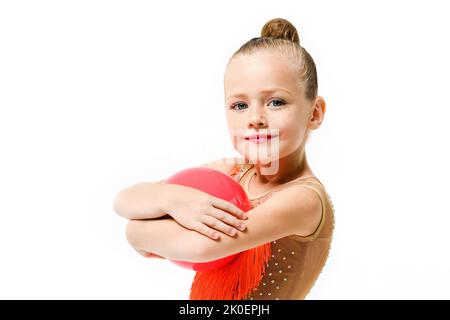 Little girl gymnast studio portrait with rubber ball, artistic acrobatics and professional sport for kids Stock Photo