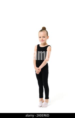 Lovely small gymnast acrobat dancer girl in black leotard with makeup full length stand on toes at isolated background Stock Photo