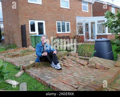 SITTING ON THE FENCE. ALAN CRAVEN OPF THE KEEP, PORTCHESTER SITS ON HIS GARDEN WALL WHICH WAS BLOWN DOWN IN THW STORM. PIC MIKE WALKER, MIKE WALKER PICTURES,2013 Stock Photo