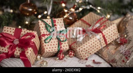 Festive gift boxes under the Christmas tree, close-up. Stock Photo