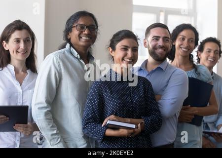 Happy cheerful multiethnic business project team standing together in office Stock Photo