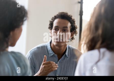 Serious motivated business team employee talking to coworkers Stock Photo