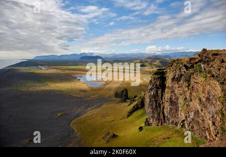 Wide rocky landscape and black sand beach seen from cape Dyrholaey viewpoint near Vik, South coast, Iceland Stock Photo