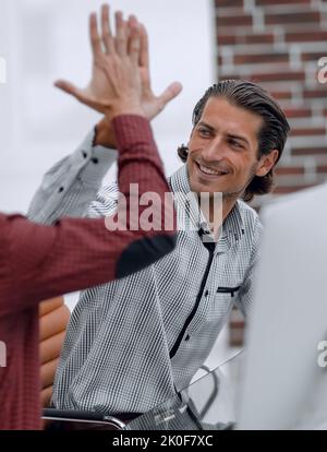 Two happy employees giving high five in office, celebrating success or ...