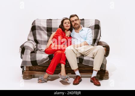 Portrait of couple, man and woman watching TV, movie together with interest isolated on white background. Romantic film Stock Photo