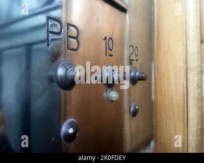 Vintage brass intercom system on classic wooden door frame Stock Photo