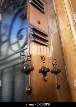 Vintage brass intercom system on classic wooden door frame Stock Photo