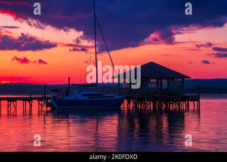 Exciting long exposure landscape on a lake with Yacht and wooden small house in the water Stock Photo
