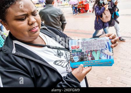 Bogota Colombia,San Victorino Carrera 10,Centro downtown handout handing out Black African female woman flyer information advertising ad Spanish langu Stock Photo