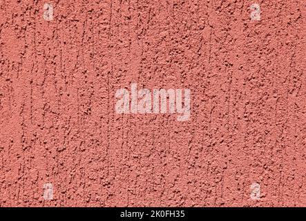 Red wall, texture, background. Plastered building wall. Rough,  textured and decorated surface with vertical embossed pattern. Chaotic picture Stock Photo