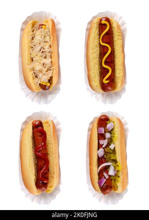 Four different hotdogs on paper holders with different condiment toppings isolated on white. Stock Photo