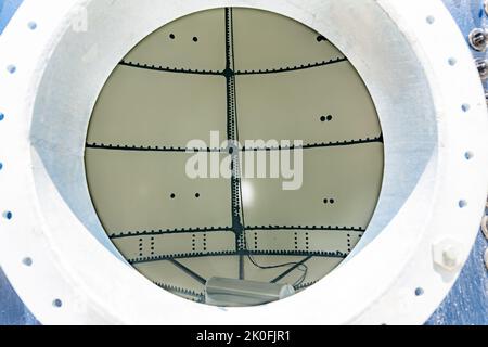 Image through access point into the interior, inside, of a new nondescript empty above ground steel bulk water storage tank, confined space. Stock Photo