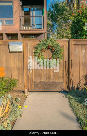La Jolla, California- Wooden gate in between stone pillars and concrete ...