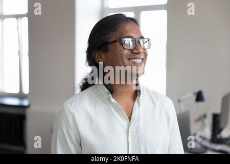 Happy Indian business startup leader man in glasses looking away Stock Photo