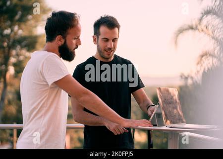 Two young entrepreneur men having a business talk while working online with their tablets Stock Photo