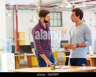 Designing duo. two coworkers using a digital tablet together in an office. Stock Photo