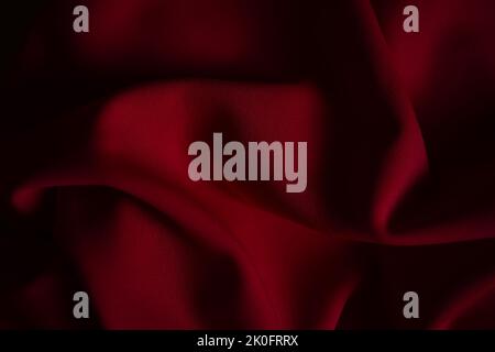 Closeup wrinkled dark red jersey, soft fabric background. Stock Photo