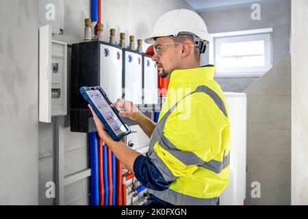 Electrical technician looking focused while working in a switchboard with fuses. Stock Photo