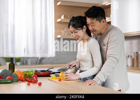 Loving korean woman cooking for her husband Stock Photo