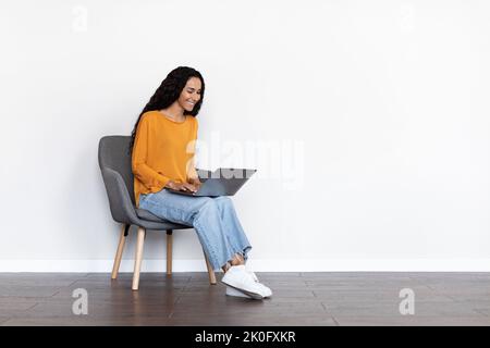 Pretty young woman freelancer using computer at home, copy space Stock Photo