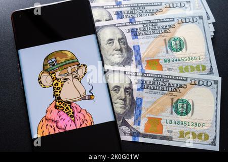 Bored Ape #6723 NFT seen on the smartphone screen placed on pile of dollar bills. Snoop Dogg’s NFT. Stafford, United Kingdom, September 11, 2022. Stock Photo