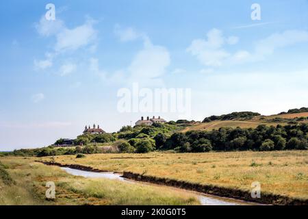 SEAFORD, ENGLAND - JULY 9th, 2022: View of the river Cuckmere and the coastgard cottages in summer, East Sussex, England Stock Photo