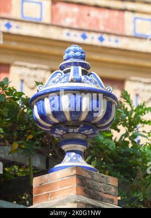 Colored ceramic top vase close to Palace of San Telmo, Seville, Andalusia, Spain. Brick wall top Stock Photo