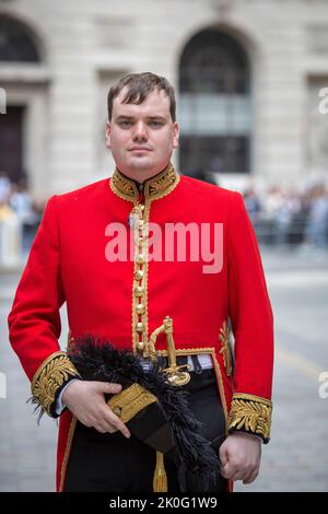 Male wearing a Red coat British Army uniform standing outside the Royal Exchange in the City of London, UK Stock Photo