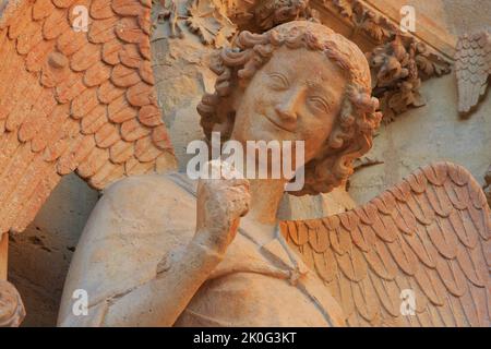 The Smiling Angel (Smile of Reims), carved between 1236-1245, on the north portal of the west facade of Reims Cathedral (Marne), France Stock Photo