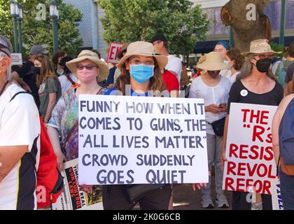 Oakland, CA - June 11, 2022:  Participants at the March for our Lives Protest Rally at Frank H Ogawa Plaza in Oakland, holding signs demanding action Stock Photo