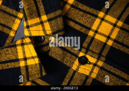Defocus black and yellow checkered shirt. Gingham tablecloth back pattern. Fragment of a wrinkled squared black and white shirt cloth fabric as a back Stock Photo