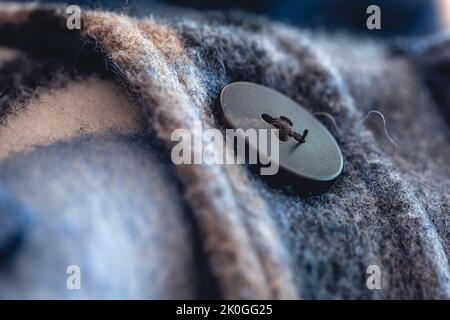 Button on a warm blue shirt, macro shot. Stock Photo