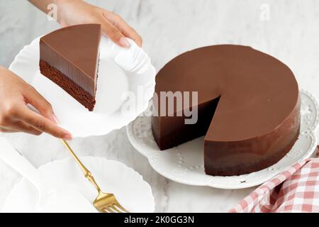 Women Hand Served Slice of Homemade Dessert Puding Cokelat or Chocolate Pudding on White Plate Stock Photo