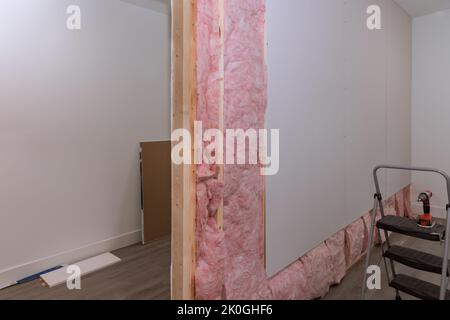 Screwing drywall on beams framing after installing sound and thermal insulation Stock Photo