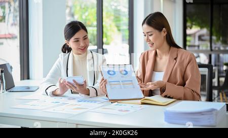 Professional young Asian female accountants or financial analysts present their financial data reports during the meeting with their boss. Businesspeo Stock Photo