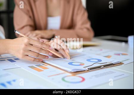 A team of professional business and financial analysts analyzing a financial data on the report together. cropped image Stock Photo
